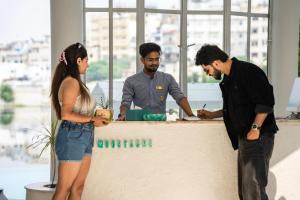 eine Gruppe von drei Personen, die um einen Schreibtisch stehen in der Unterkunft Moustache Udaipur Verandah in Udaipur