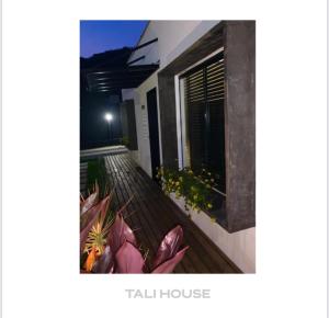 a balcony of a house with flowers on it at TALI HOUSE - Casa Hotel in São Francisco do Sul