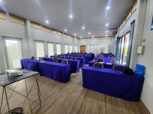 ナコーンパトムにあるBusaya Resort & Cuisineの青いテーブルと椅子が備わる広い客室です。