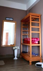 a room with a book shelf with a mirror and a vase at Hotel Comfy Stay Tawang in Tawang