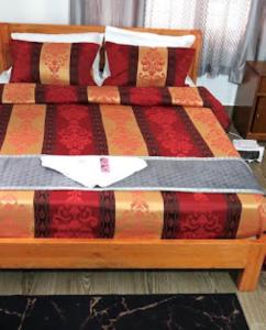 Bett in einem Zimmer mit farbenfroher Bettdecke in der Unterkunft Hotel Comfy Stay Tawang in Tawang