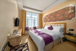 a hotel room with a large bed and a window at Qihang Hotel Harbin Taiping Airport in Harbin