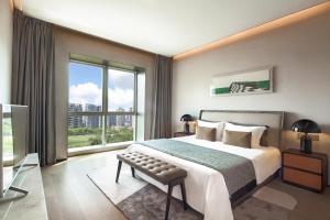 um quarto com uma cama grande e uma janela grande em Artisse Place - Access to 4000 sqm Fusion Wellness Centre and 800 sqm Indoor Swimming Pool em Shenzhen