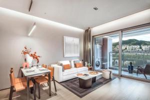 uma sala de estar com um sofá branco e uma mesa em Artisse Place - Access to 4000 sqm Fusion Wellness Centre and 800 sqm Indoor Swimming Pool em Shenzhen