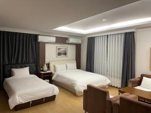 a hotel room with two beds and a table at Hotel Terramar in Boryeong