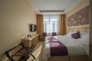 een hotelkamer met een bed en een televisie bij Qihang Hotel Harbin Taiping Airport in Harbin