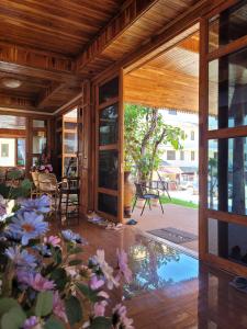 an open living room with a glass door and flowers at Kum-Chan House Hotel (เฮือนก่ำจันทร์) in Nan