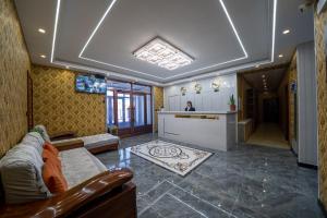 een woonkamer met een bank en een keuken bij Qihang Hotel Harbin Taiping Airport in Harbin