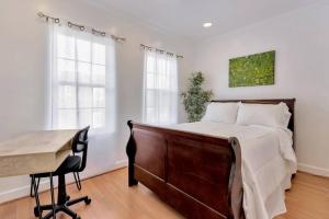 um quarto com uma cama, uma secretária e janelas em DC A lovely urban oasis condo em Washington