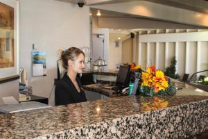 a woman standing behind a counter with a flowers at Greenwell Inn in Price