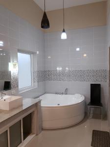 biała łazienka z wanną i umywalką w obiekcie Luxury Private Pool Villa 5 min from Walking Street and Beaches w Pattaya South