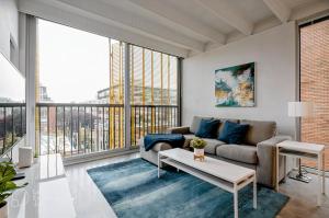 uma sala de estar com um sofá e uma grande janela em Modern, Bright & Beautiful, 1 Bedroom Downtown Apt with Rooftop Patio em Vancouver