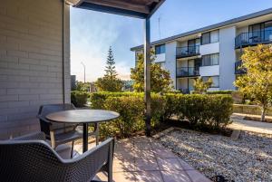 a patio with a table and chairs and a building at Riverside Elegance Central 1BR 1BA Apartment in Perth