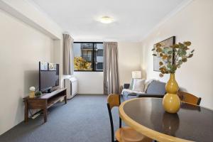 - un salon avec un vase de fleurs sur une table dans l'établissement Riverside Elegance Central 1BR 1BA Apartment, à Perth