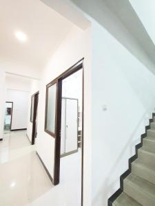 a staircase in a house with a glass door at Kos Harian Wisma Selma Garuda in Kejayan