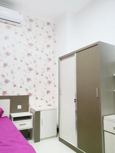 ein Schlafzimmer mit rosa Blumen an der Wand in der Unterkunft Kos Harian Wisma Selma Garuda in Kejayan