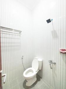 a bathroom with a toilet and a shower at Kos Harian Wisma Selma Garuda in Kejayan