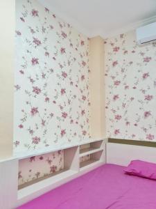 ein Zimmer mit rosa Blumen an der Wand in der Unterkunft Kos Harian Wisma Selma Garuda in Kejayan