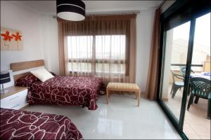 Un dormitorio con una cama y una mesa y una ventana. en Apartamentos Lomas De Campoamor, en Campoamor 31 fotos más