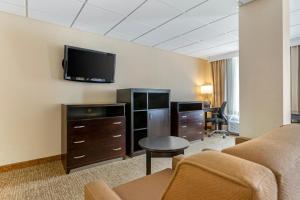 Habitación de hotel con sofá y TV en la pared en Comfort Inn & Suites, en Triadelphia