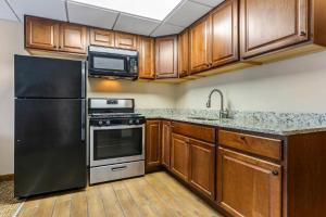 a kitchen with a black refrigerator and a microwave at Comfort Inn & Suites in Triadelphia