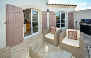 エーグ・モルトにあるNice Home In Aigues-mortes With 3 Bedrooms And Wifiのピンクのドア、椅子、テーブル付きのパティオ