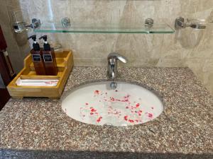 a bathroom sink with flowers on a counter at Nhat Linh hotel & Apartment in Danang