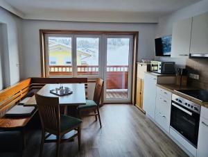 a kitchen with a table with chairs and a dining room at Ferienwohnung Ingrid Hörbiger in Mittersill