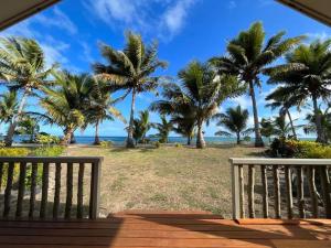 eine Veranda mit Blick auf den Strand und die Palmen in der Unterkunft Mai Sunset Island Resort in Naviti Island