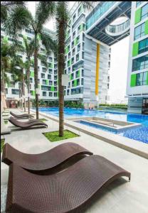 胡志明市的住宿－Republic Apartment Nearby Airport Free Pool Gym，一座建筑物前的游泳池,设有棕色长凳