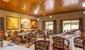 - un restaurant avec des tables et des chaises dans une salle dans l'établissement Kuruman Lodge, à Kuruman