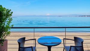 einen Tisch und Stühle auf einem Balkon mit Meerblick in der Unterkunft Scapes The Suite in Hayama