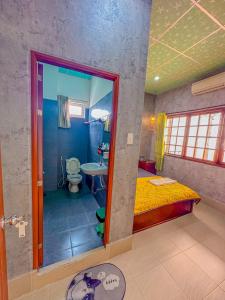 a bedroom with a bed and a bathroom with a toilet at Hoàng Sơn's Home in Can Tho