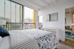 um quarto com uma cama e uma grande janela em Modern, Bright & Beautiful, 1 Bedroom Downtown Apt with Rooftop Patio em Vancouver