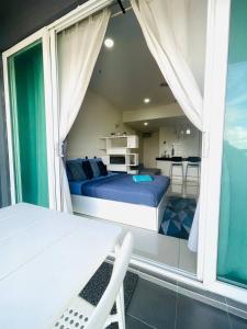 1 dormitorio con cama, mesa y cocina en Moonstone studio D'Perdana Apartment, en Kota Bharu