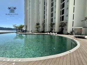 a swimming pool in front of a building at Borneotel The Shore KK by CHG in Kota Kinabalu