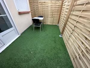 um pequeno pátio com uma mesa e uma cadeira em Appart , maison, équipée avec terrasse ,près centre ville em Saint-Jean-le-Blanc