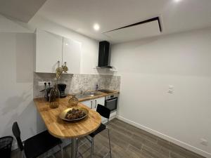 cocina con mesa de madera y fregadero en Appart , maison, équipée avec terrasse ,près centre ville, en Saint-Jean-le-Blanc