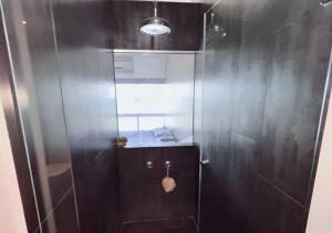 uma casa de banho com um chuveiro e uma porta de vidro em Suite Coco CarIbe em Porlamar