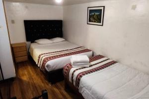 Habitación con 2 camas en una habitación en Q'osqo Apartments, en Cusco