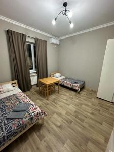 Habitación con 2 camas y mesa. en Гостевой Отель-125 en Aktau