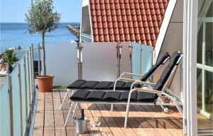 una fila de sillas en un balcón con vistas al océano en 3 Bedroom Amazing Apartment In Karrebksminde, en Karrebæksminde