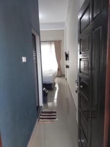 a hallway with a room with a bed and a door at Kala Guest House in Kabanjahe