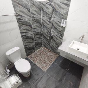 Kala Guest House في Kabanjahe: حمام مع مرحاض ومغسلة