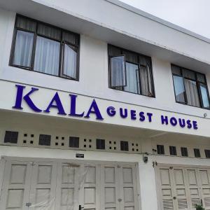 Kala Guest House في Kabanjahe: مبنى عليه لافتة بيت ضيافة كالا