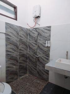 y baño con ducha y lavamanos. en Kala Guest House, en Kabanjahe