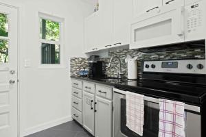 a kitchen with white cabinets and a black stove top oven at Condo by the Beach King Bed Lush Patio w BBQ Breakers Key Three H0MES in Fort Lauderdale +11 photos