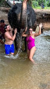 two people standing in the water with an elephant at At Thara Aonang in Ao Nang Beach