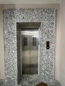 um elevador de metal num edifício com um espelho em Shrinath Palace em Deoghar