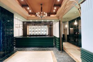 a dressing room with green walls and a chandelier at 瑞昊國際商旅-家美瑞品-JiaMei Hotel in Taipei